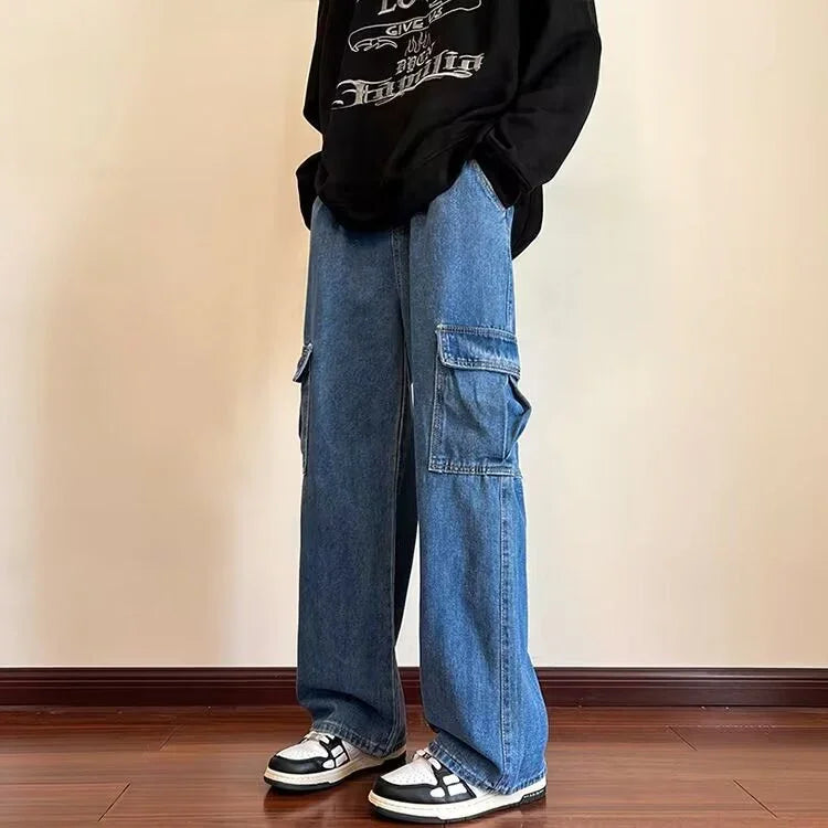 Person wearing wide-leg blue denim cargo pants and black and white sneakers on wooden floor