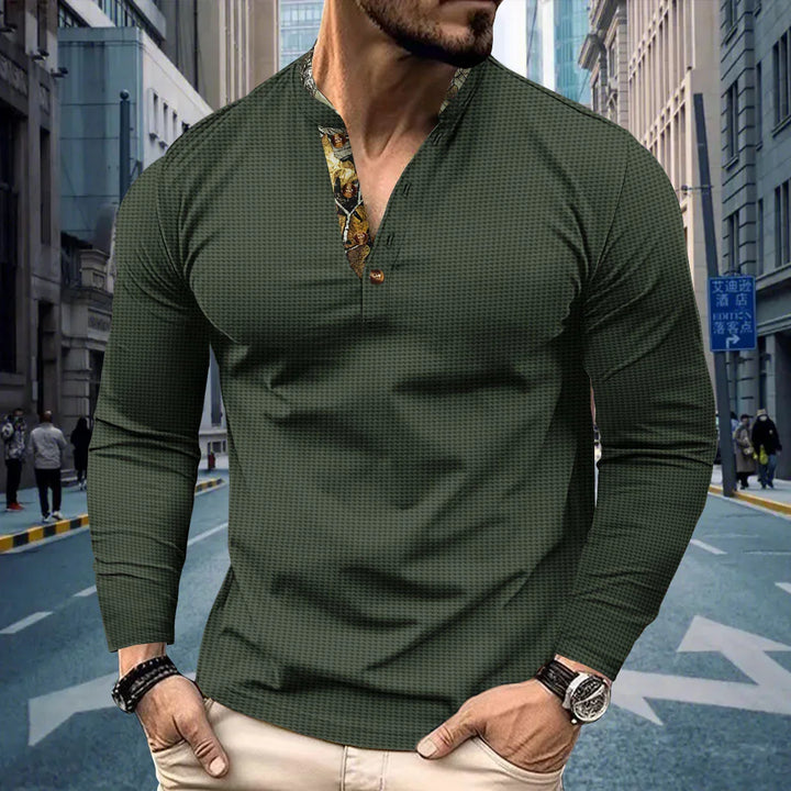 Man wearing dark green textured long sleeve shirt with floral inner collar on urban street