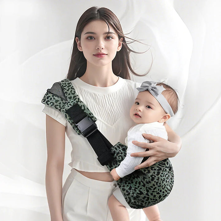 Young woman wearing white outfit holding baby in green leopard print baby carrier with gray bow headband