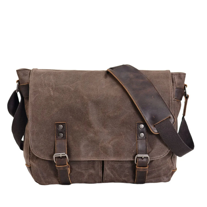 brown canvas messenger bag with leather straps and adjustable shoulder pad on white background