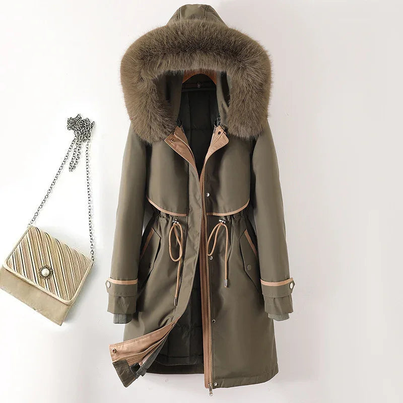 Olive green winter parka with fur hood and beige trim hanging next to quilted chain strap handbag