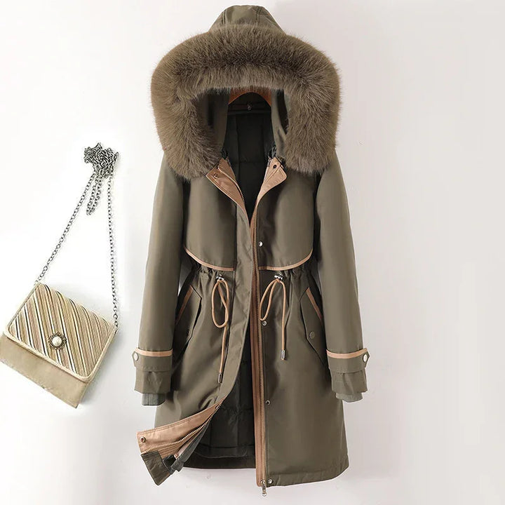 Olive green winter parka with fur hood and beige trim hanging next to quilted chain strap handbag