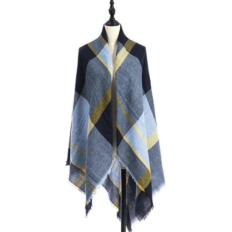 Blue and yellow plaid shawl with fringed edges displayed on dress form against white background