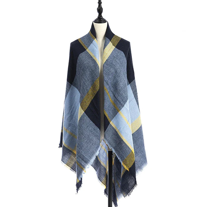 Blue and yellow plaid shawl with fringed edges displayed on dress form against white background