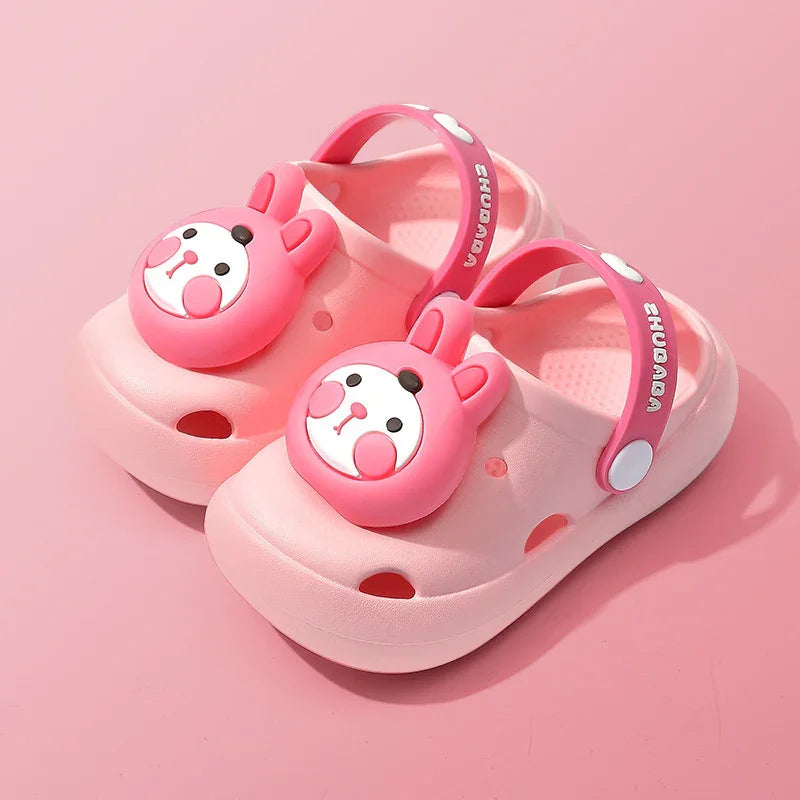 Pink toddler clogs with cute bunny face embellishments and adjustable straps on a pink background