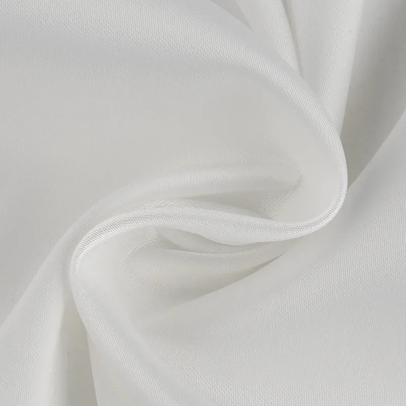 Close-up of smooth white fabric with fine texture and gentle folds