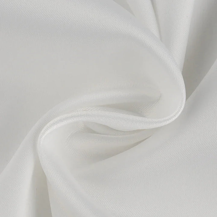 Close-up of smooth white fabric with fine texture and gentle folds