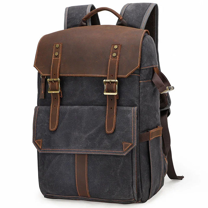 vintage black canvas backpack with brown leather flap, straps, and brass buckles for travel and daily use