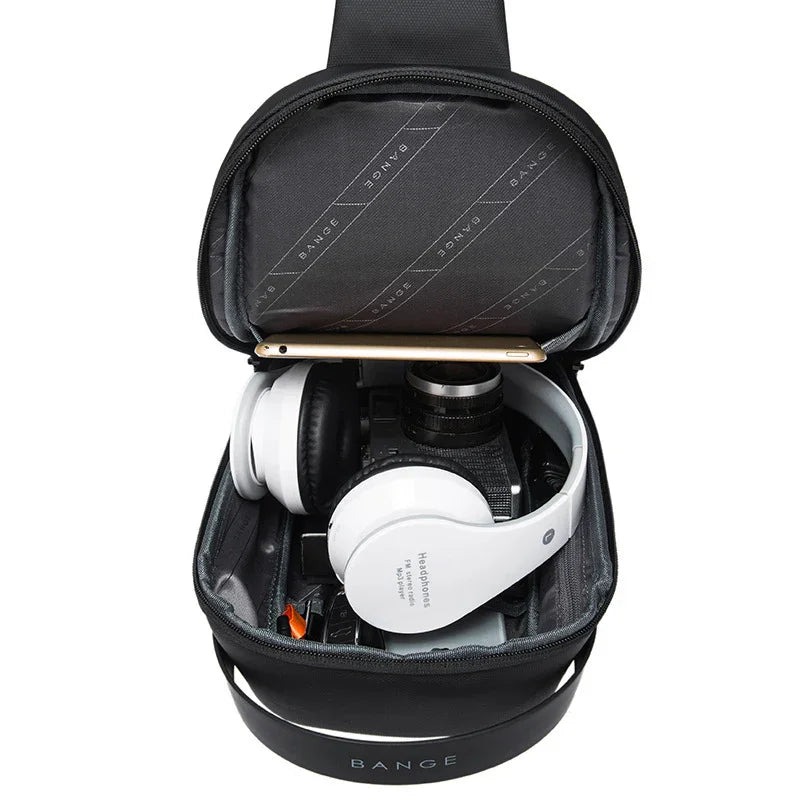 Black BANGE travel bag with white headphones, camera, and smartphone inside