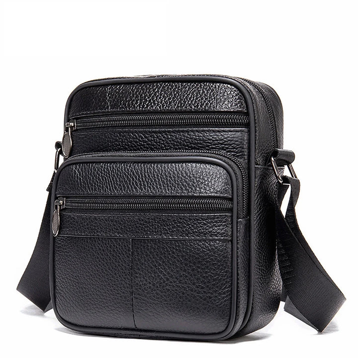 Black textured leather crossbody bag with multiple zippered compartments and adjustable strap