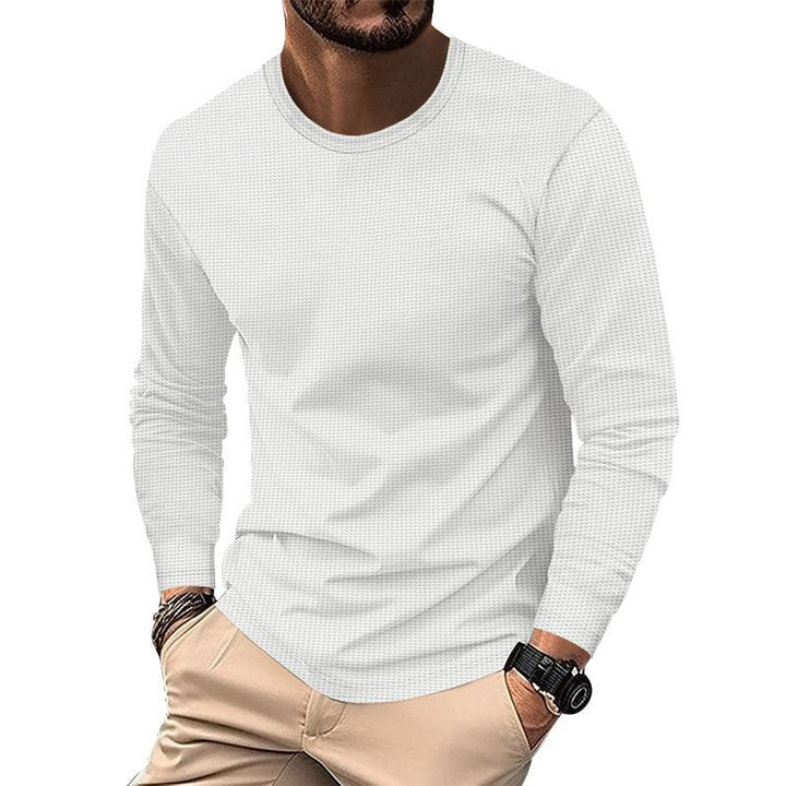 Man wearing white textured long sleeve shirt and beige pants with wristwatch and bracelets