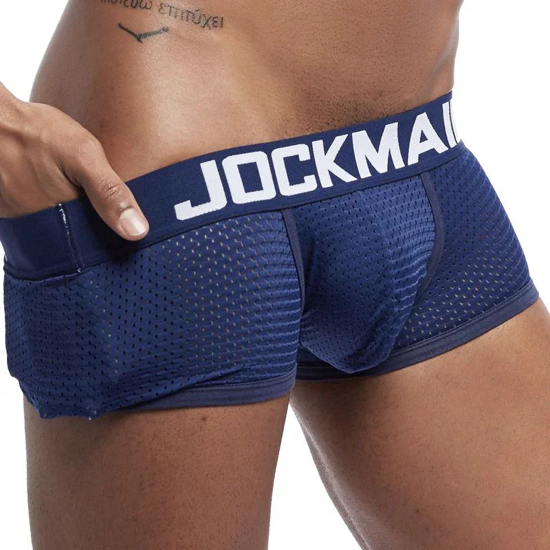 Close-up of a man wearing navy blue breathable mesh Jockmail men's underwear with branded waistband