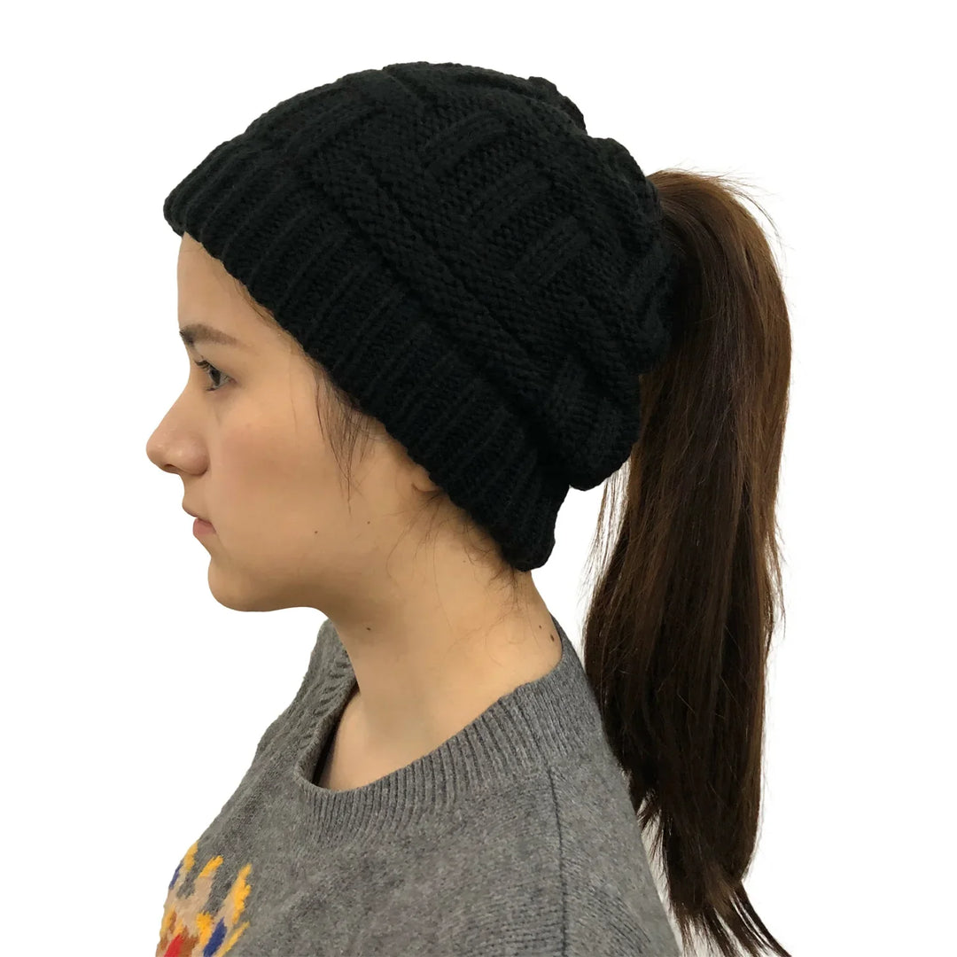 Woman wearing black knit ponytail beanie with long brown hair and gray sweater