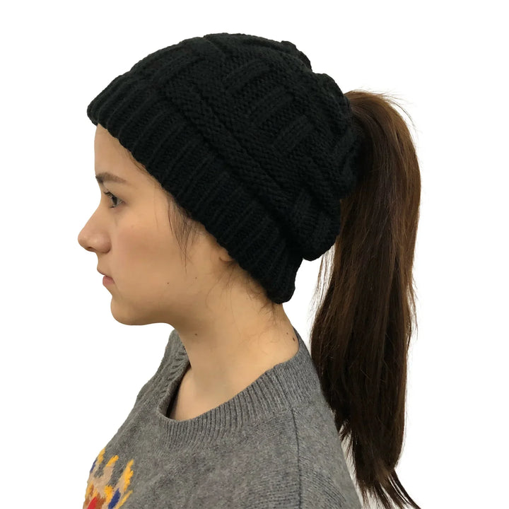 Woman wearing black knit ponytail beanie with long brown hair and gray sweater
