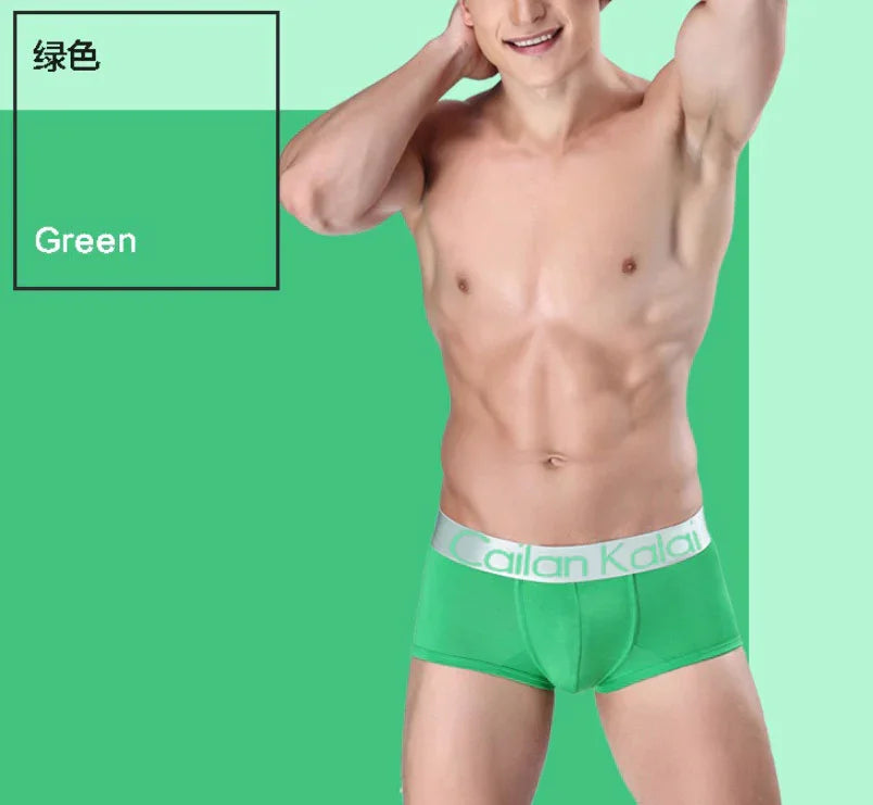 Muscular man wearing bright green Cailan Kalai boxer briefs against green background with text 'Green'