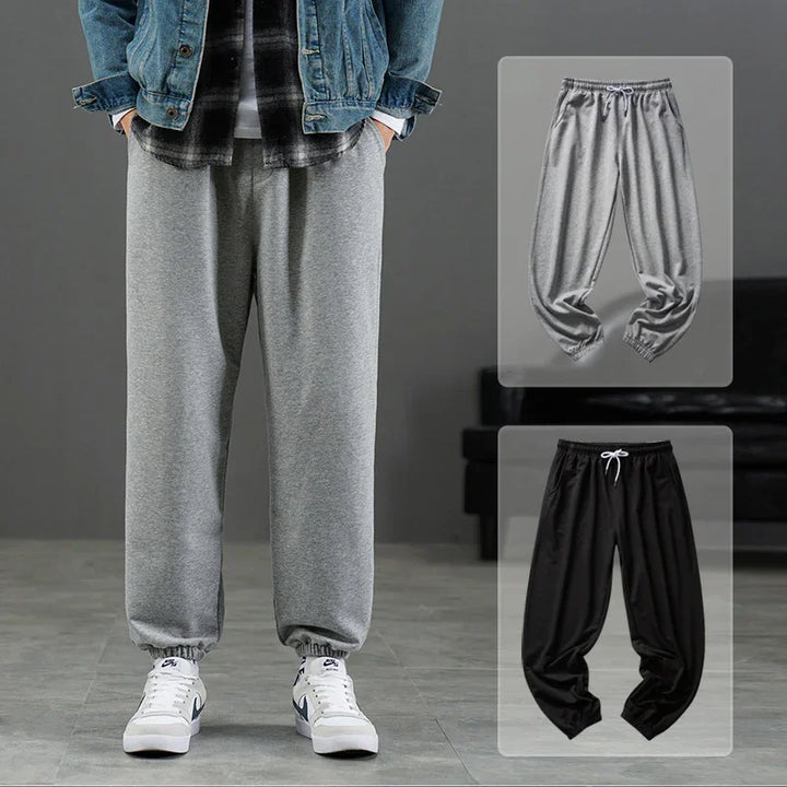 Casual gray sweatpants with elastic cuffs worn with denim jacket and white sneakers, plus gray and black sweatpants on display