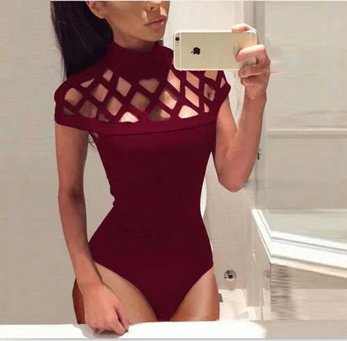 Woman taking a mirror selfie wearing a burgundy bodysuit with lattice cutout design on the chest and shoulders