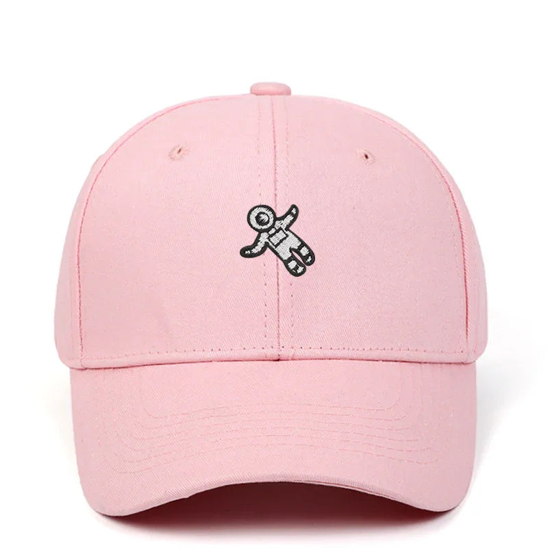 Pink baseball cap with a small black and white astronaut patch embroidered on front