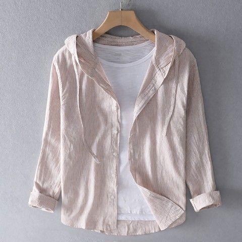 Beige button-up corduroy shirt with hood and white t-shirt on wooden hanger against gray wall