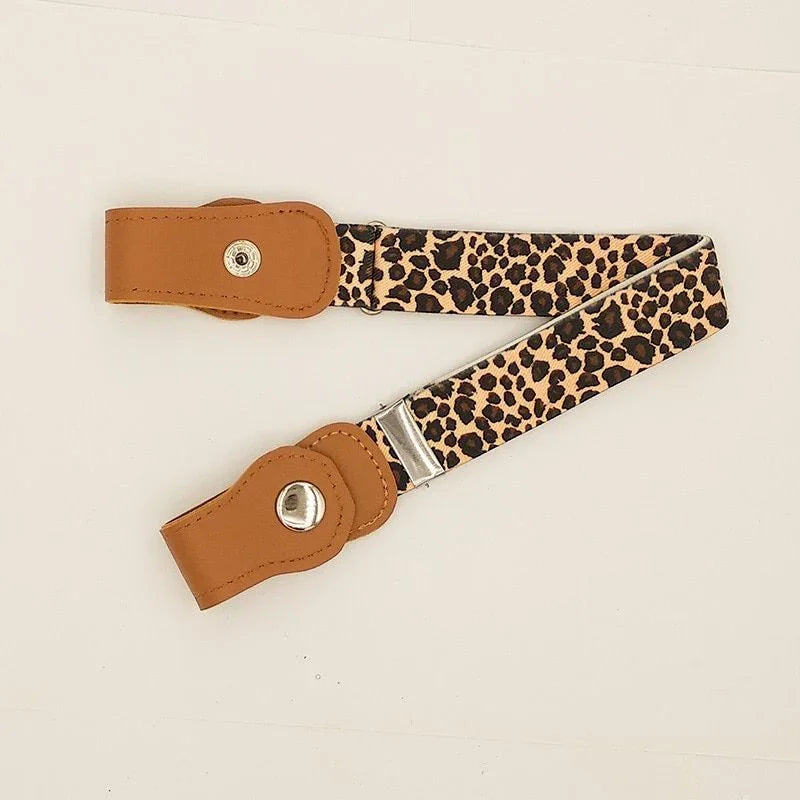 Leopard print fabric belt with tan leather ends and silver button closures on white background