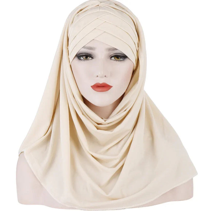 Mannequin head wearing beige layered hijab with soft folds and smooth fabric