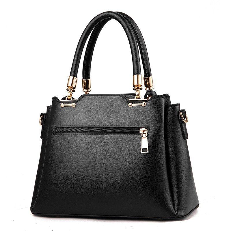 Elegant black leather handbag with gold hardware and dual top handles on white background