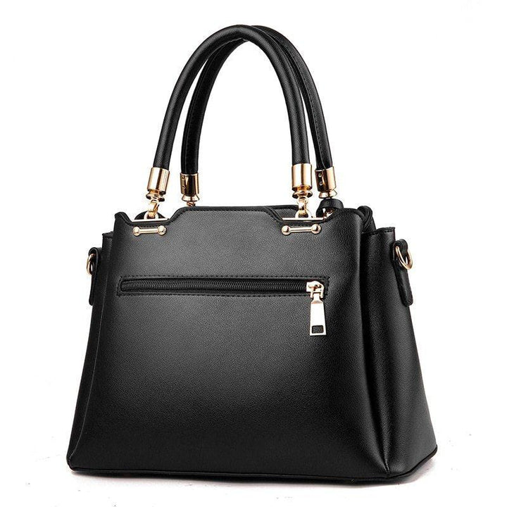 Elegant black leather handbag with gold hardware and dual top handles on white background