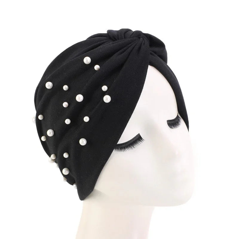 Black turban headband with scattered white pearl beads on mannequin head