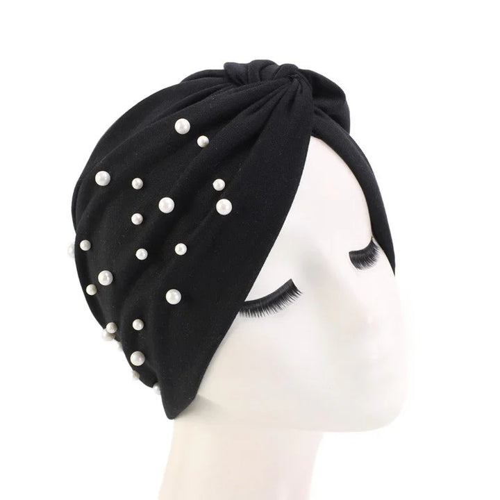Black turban headband with scattered white pearl beads on mannequin head