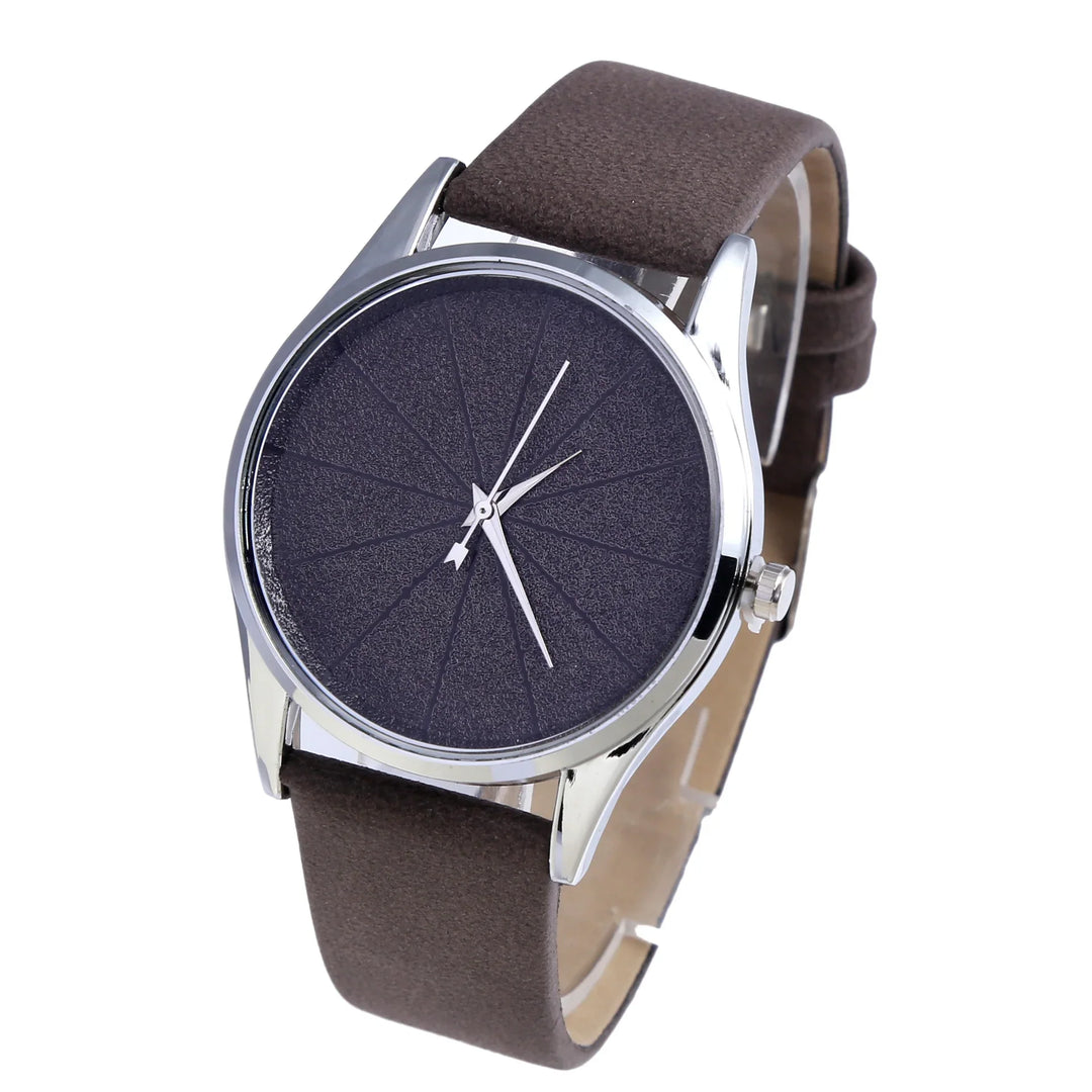 Minimalist wristwatch with textured black dial, silver case, and brown leather strap