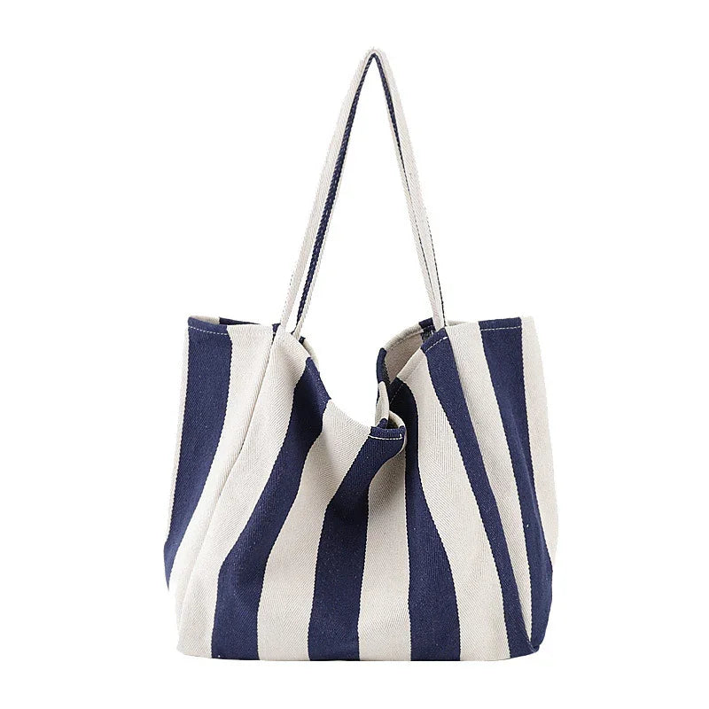 Navy blue and white striped fabric tote bag with shoulder straps on white background