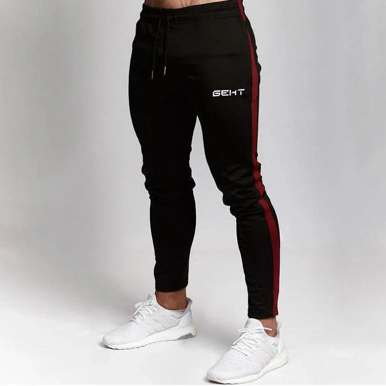 Black jogger pants with red side stripes and white branding, paired with white athletic sneakers