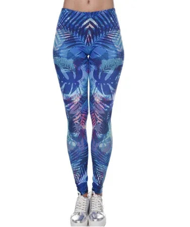 woman wearing high-waisted blue tropical print leggings with silver sneakers on white background