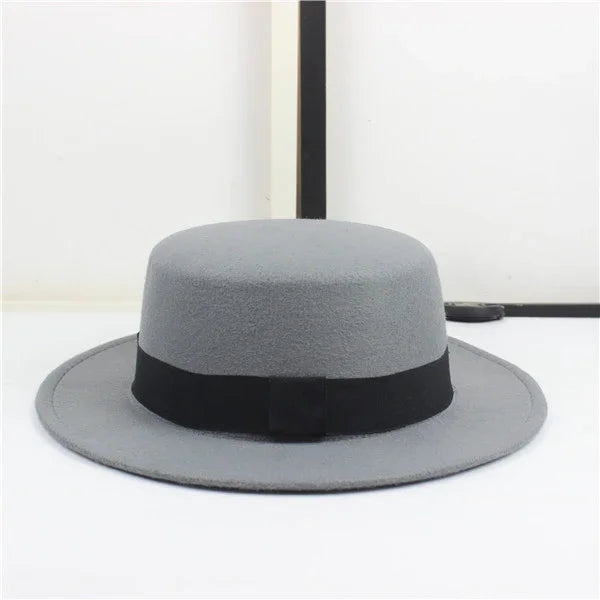 Gray felt fedora hat with black band and bow on white background