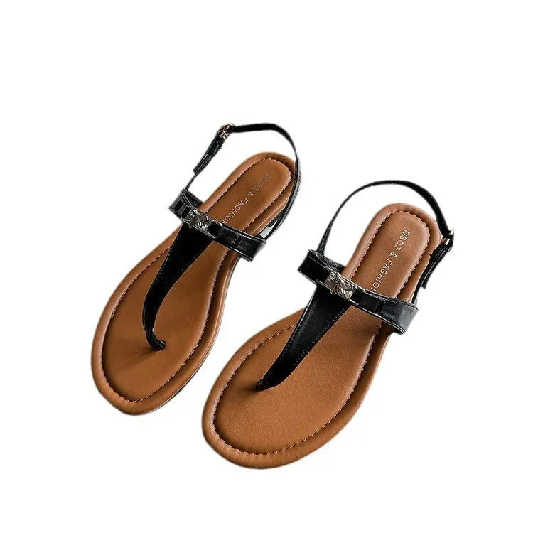 Pair of black and brown leather fashion sandals with ankle straps and toe loop on white background