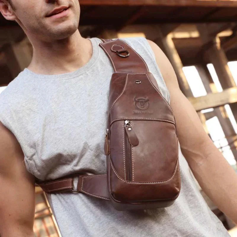 Man wearing brown leather crossbody sling bag with zippered pocket and embossed logo