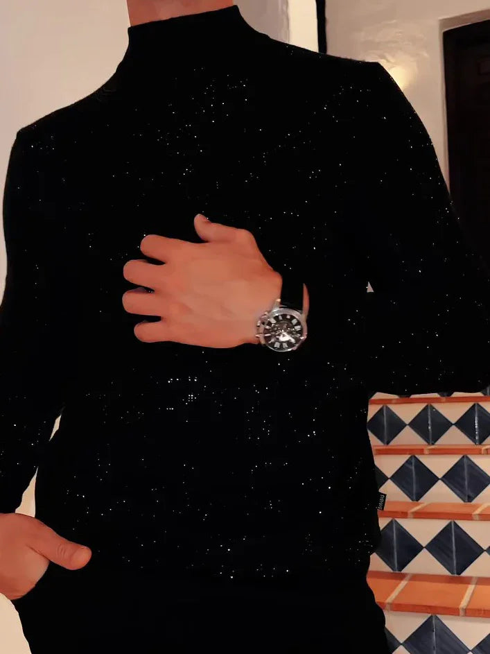 Person wearing a black glittery turtleneck sweater and a silver wristwatch standing near tiled stairs.