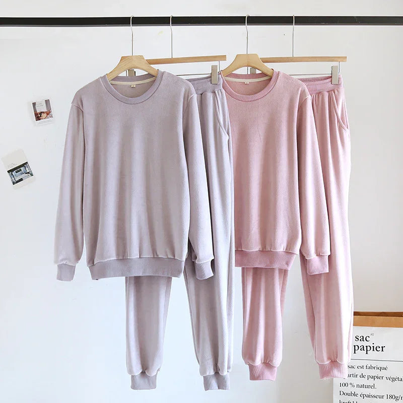 Soft lilac and pink cozy fleece loungewear sets with long sleeves and jogger pants on wooden hangers
