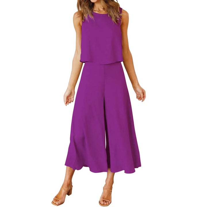 Woman wearing sleeveless purple wide-leg jumpsuit with cropped top and block heel sandals