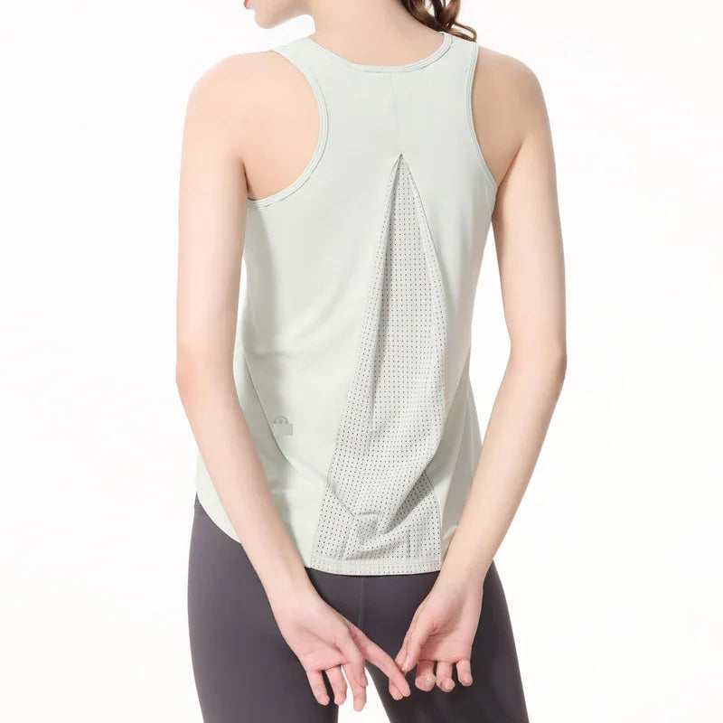 Woman wearing light gray racerback tank top with mesh back panel and black leggings