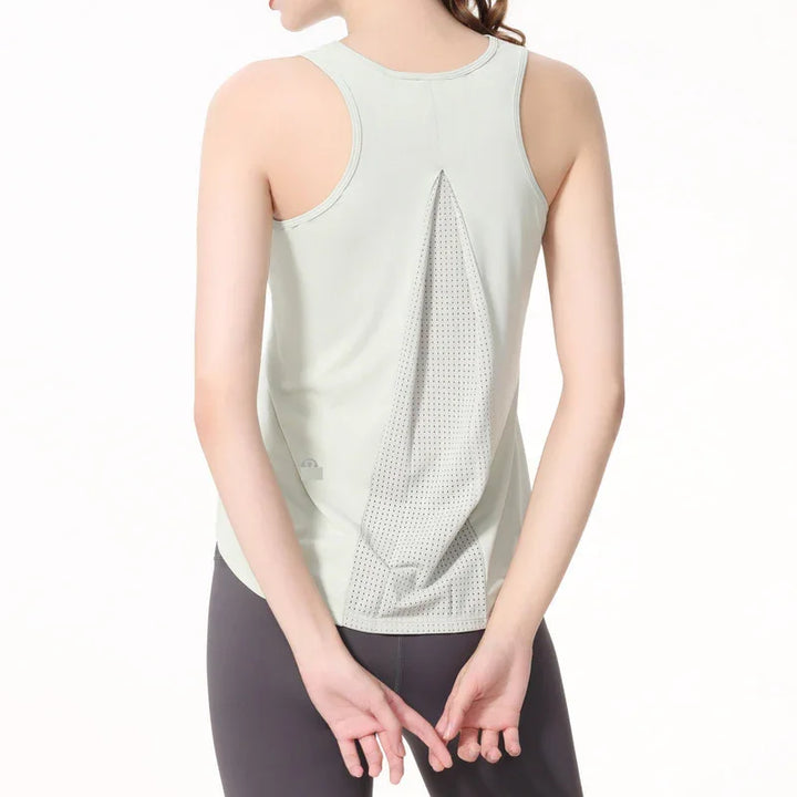 Woman wearing light gray racerback tank top with mesh back panel and black leggings