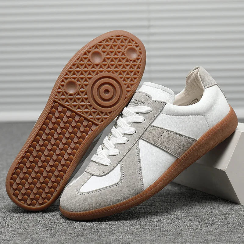 White and gray casual sneakers with gum rubber sole featuring circular and textured tread pattern