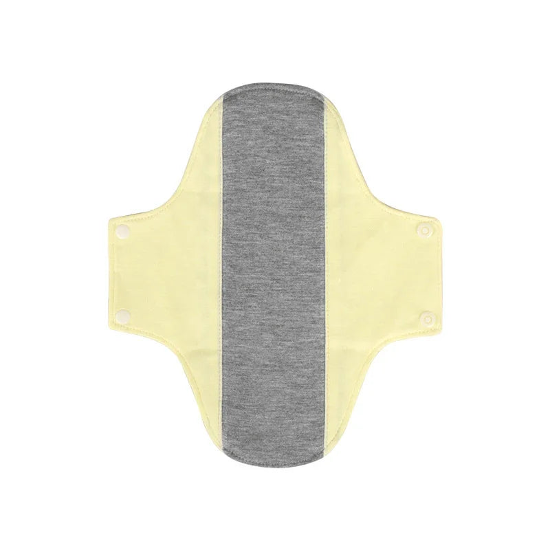 Reusable cloth menstrual pad with yellow wings and grey absorbent center, snap buttons on wings