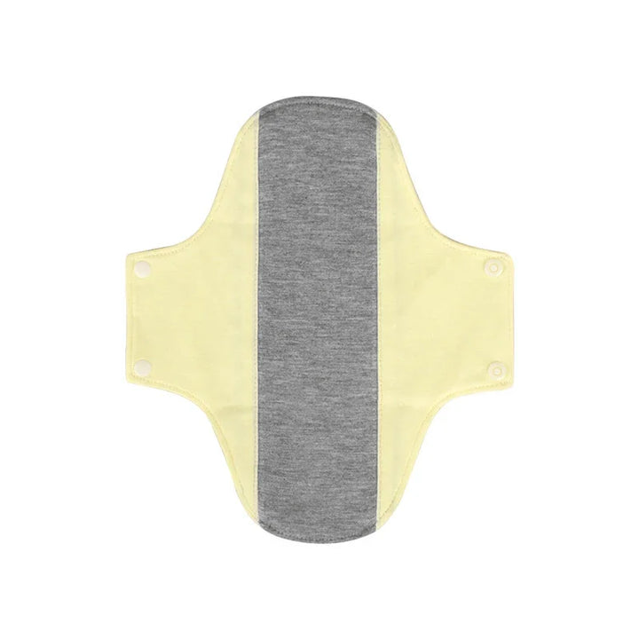 Reusable cloth menstrual pad with yellow wings and grey absorbent center, snap buttons on wings
