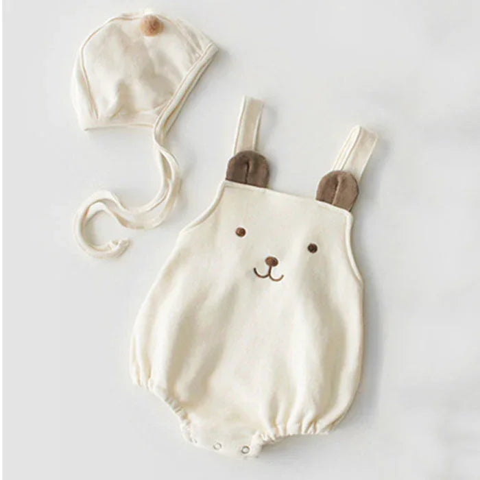 Cream-colored baby romper with bear face and ears, paired with matching bonnet hat