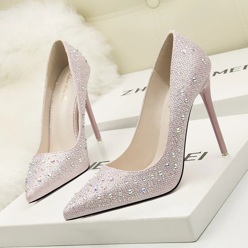 Elegant pink high heel pumps adorned with sparkling rhinestones on white display boxes