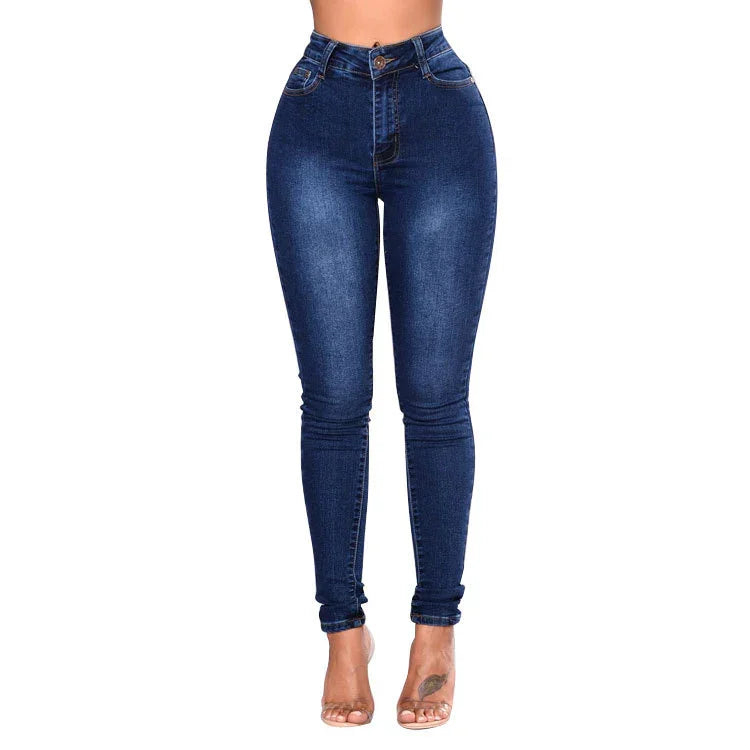 High waist dark blue skinny jeans on model with rolled cuffs and clear heels