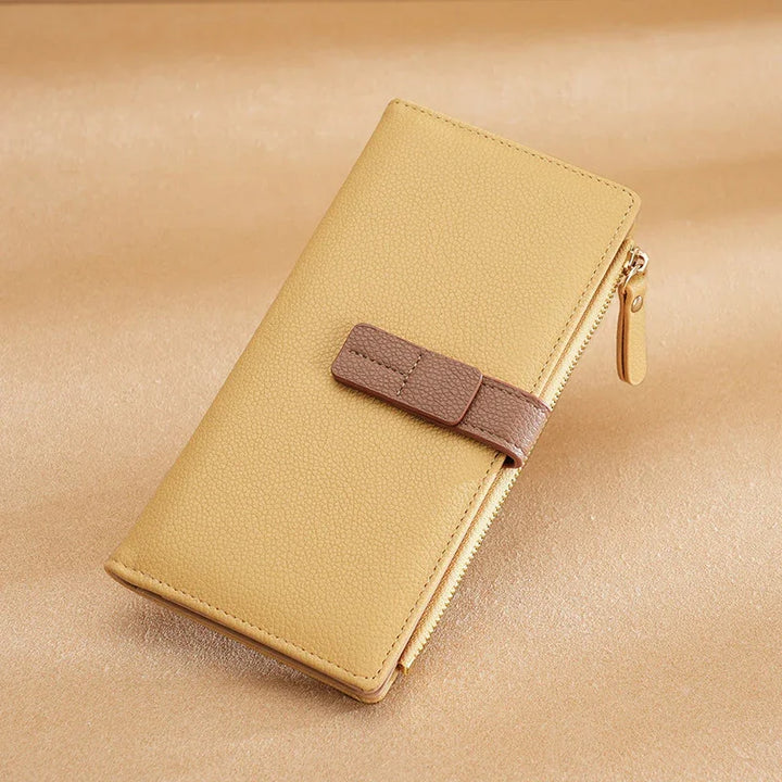 Beige leather wallet with brown strap and zipper on beige background