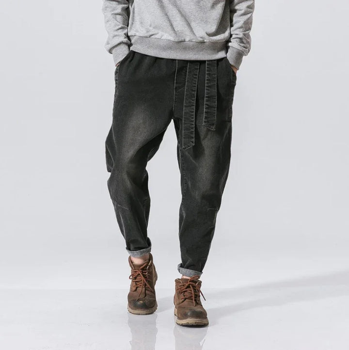 Casual black tapered pants with fabric belt worn with brown boots and grey sweatshirt