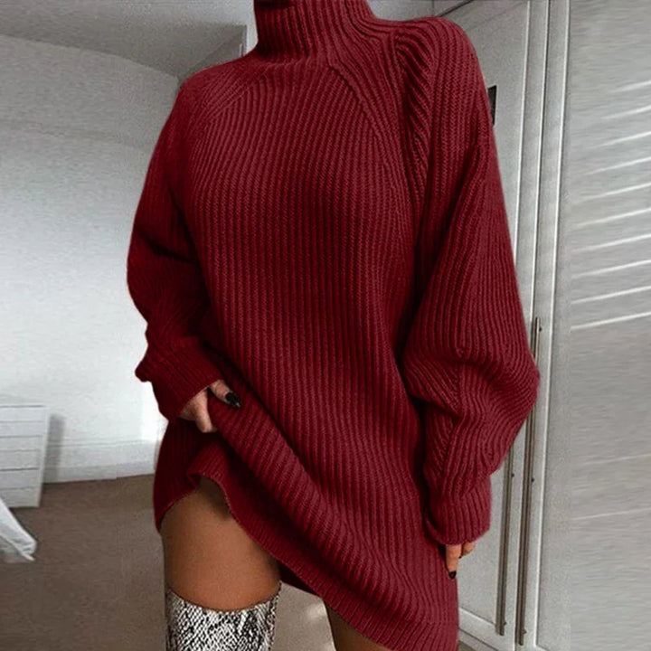 Woman wearing oversized ribbed burgundy turtleneck sweater and snakeskin knee-high boots indoors